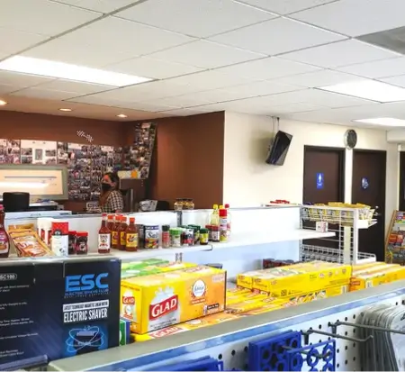 Convenience store interior with products and cashier.