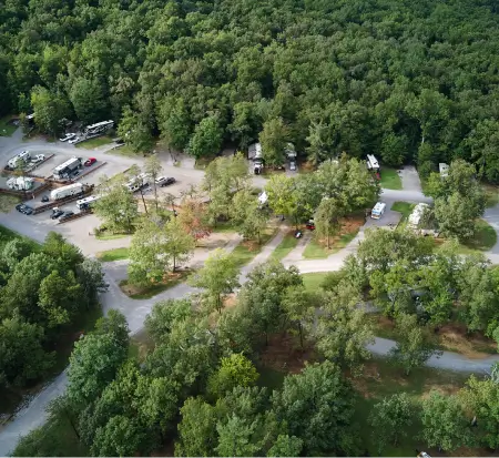 Aerial view of wooded campground with vehicles and roads.