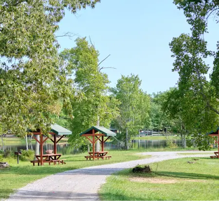 Park with picnic tables, trees, and walking path.