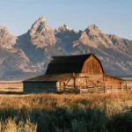 Historic barn with Grand Teton mountains in background.