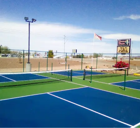 Outdoor pickleball courts under clear sky.