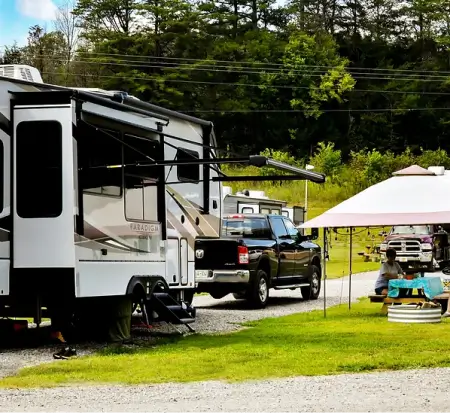 RV camping with truck and outdoor seating.