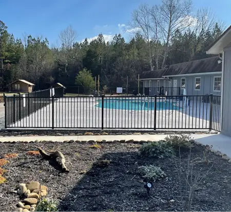 Swimming pool with fence in sunny residential backyard.