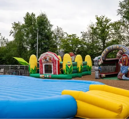 Colorful inflatable playground with bounce houses outdoors.