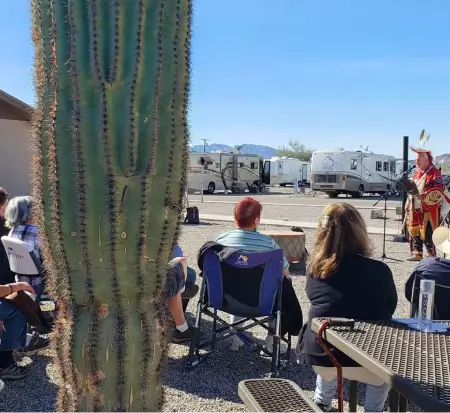 Outdoor presentation near RVs with cactus in foreground.