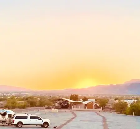 Sunset view, mountains, parking lot with vehicles.