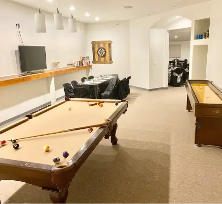 Basement game room with pool table and shuffleboard.