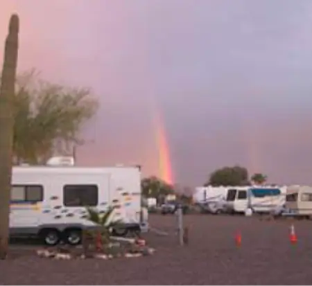Rainbow over RV campground at dusk.