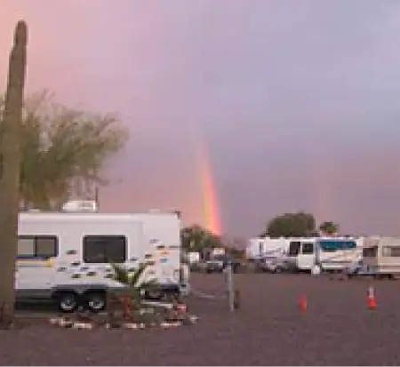 RV campground with rainbow at dusk.