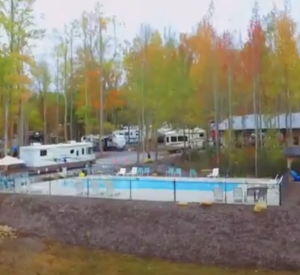 Autumnal RV park with empty pool and boats.