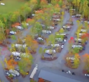 Aerial view of parking lot surrounded by autumn foliage.