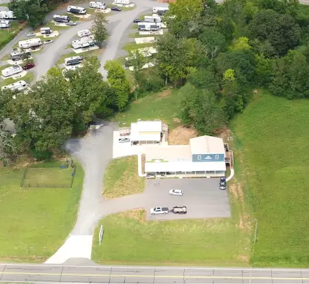 Aerial view of rural campground with RVs and building.